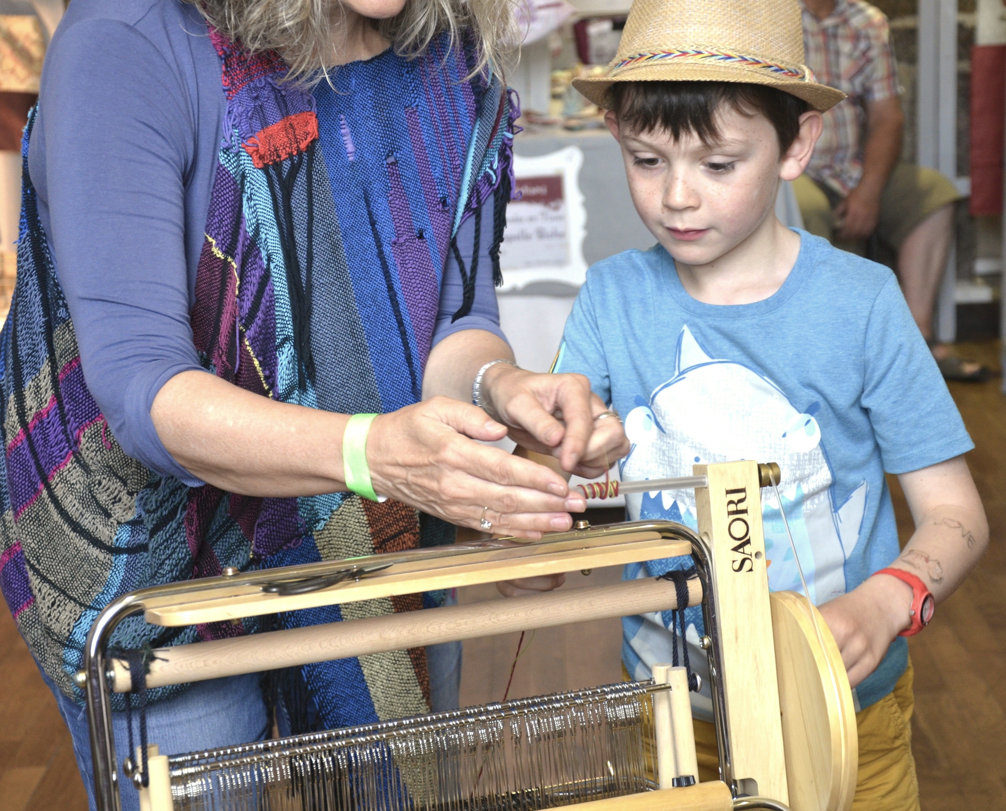 Demonstrating SAORI weaving to children, using a SAORI loom