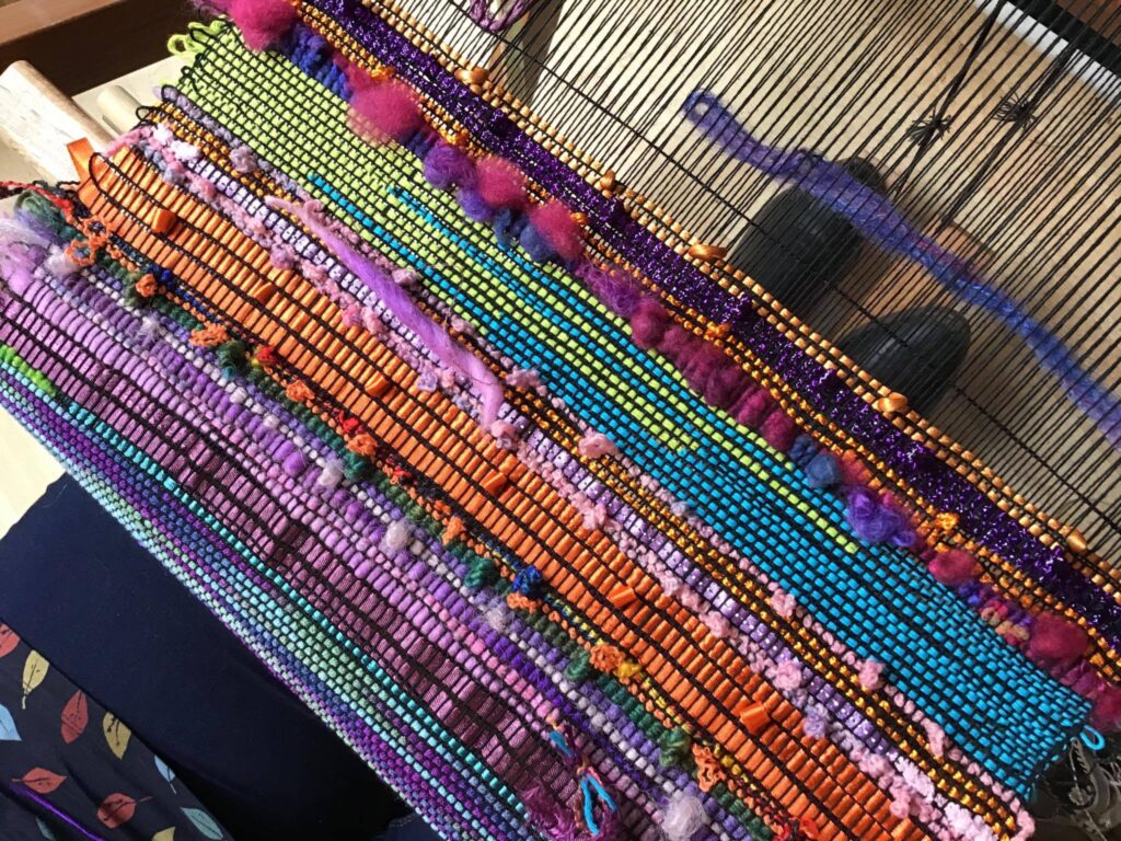 Striped multicoloured textured SAORI weaving on a loom